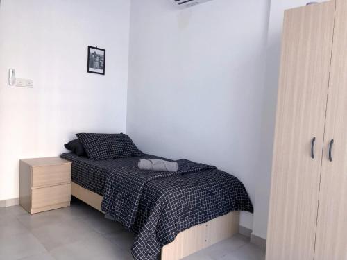 um quarto com uma cama com um cobertor preto e branco em LT Home em Sandakan