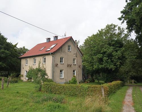 an old house with a red roof in a field at Erholen und Wohlfühlen Auf dem Knick in Detmold