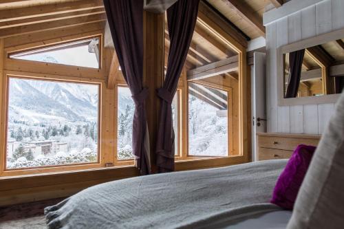 une chambre avec un lit et une grande fenêtre dans l'établissement Chalet Le Favre, à Chamonix-Mont-Blanc