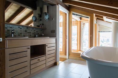 une salle de bain avec une baignoire et un lavabo dans l'établissement Chalet Le Favre, à Chamonix-Mont-Blanc