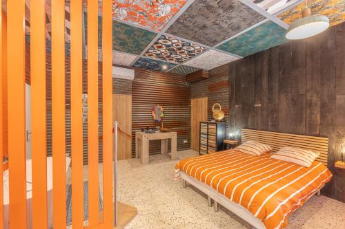 une chambre avec un lit et un mur en bois dans l'établissement La Maison du Bois Brûlé 2 - Avec piscine partagée, à Villaines-les-Rochers