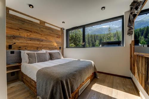 a bedroom with a bed and a large window at Chalet Red Fox in Chamonix-Mont-Blanc