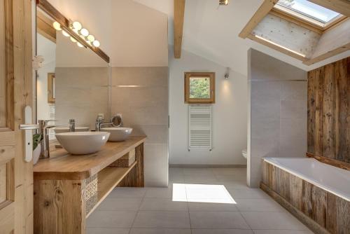 een badkamer met 2 wastafels en een bad bij Chalet Planards 2 in Chamonix-Mont-Blanc
