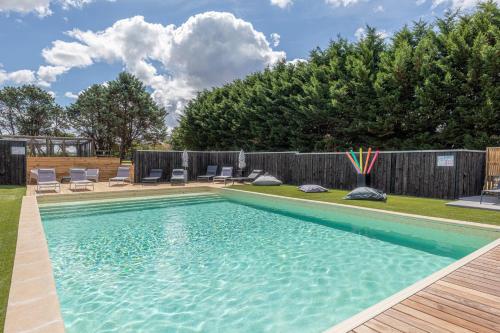 - une piscine dans une cour avec des chaises et une clôture dans l'établissement La Maison du Bois Brûlé 3 - Avec piscine partagée, à Villaines-les-Rochers