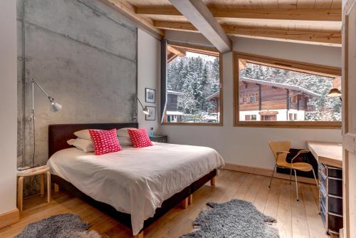 a bedroom with a bed with red pillows and a window at Chalet Caleris in Chamonix