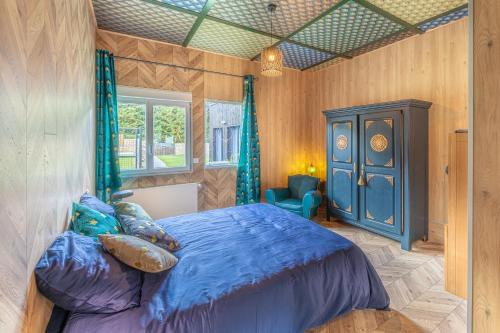 1 dormitorio con 1 cama azul y armario azul en La Maison du Bois Brûlé 3 - Avec piscine partagée, en Villaines-les-Rochers