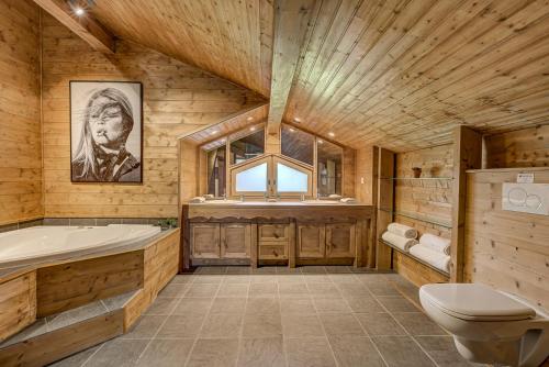 La salle de bains en bois est pourvue d'une baignoire et d'un lavabo. dans l'établissement Chalet Sanaz, à Chamonix-Mont-Blanc