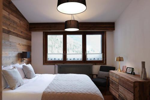 une chambre avec un lit blanc et une fenêtre dans l'établissement Le Brevent 1 Apartment, à Chamonix-Mont-Blanc