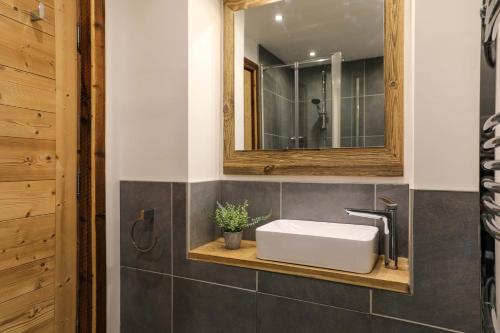 bagno con lavandino bianco e specchio di Le Brevent 1 Apartment a Chamonix-Mont-Blanc