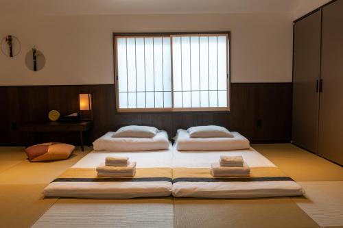 two beds in a room with a large window at Irodori Hotel SAI in Fukuoka