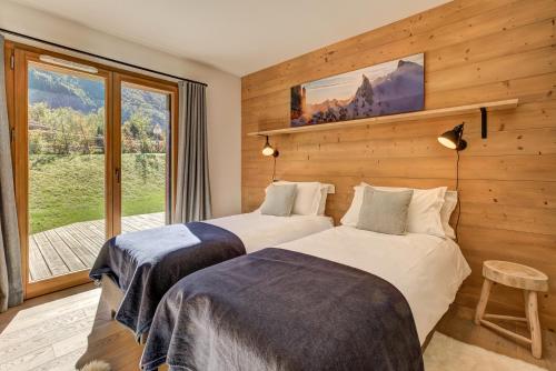 two beds in a room with a window at Residence Le Green in Chamonix