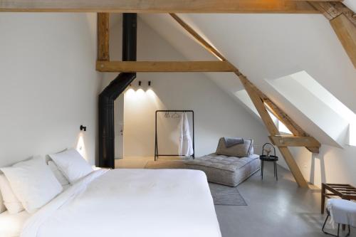 a bedroom with a white bed and a chair at Château du Pont d'Oye in Habay-la-Neuve