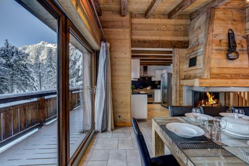 une salle à manger avec une table et une cheminée dans l'établissement Chalet Capricorne, à Chamonix-Mont-Blanc