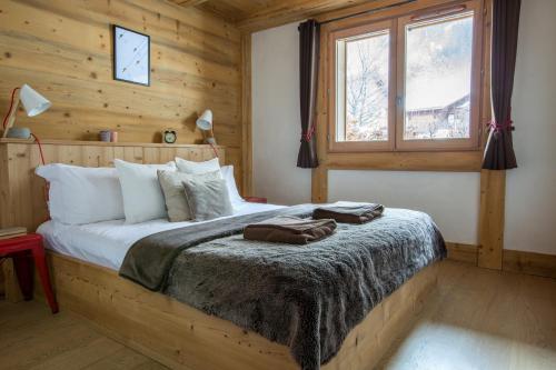 ein Schlafzimmer mit einem Bett in einem Blockhaus in der Unterkunft Blaitiere 2 Apartment in Chamonix-Mont-Blanc