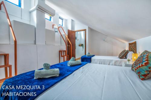 a bedroom with a large bed with blue sheets at Casas Caballerizas Mezquita 1 y 3 HAB in Córdoba