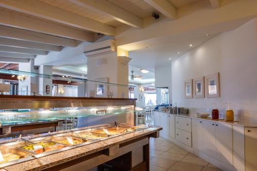 スタリスにあるKoni Village Hotelの大きなキッチン(多くの食料品のトレイ付)