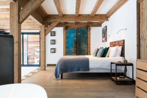シャモニー・モンブランにあるChalet Belachatの木製の天井の客室で、ベッドルーム1室(ベッド1台付)