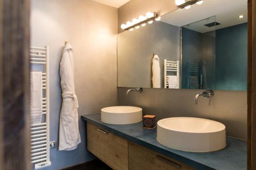 une salle de bain avec deux lavabos et un grand miroir dans l'établissement Chalet Belachat, à Chamonix-Mont-Blanc