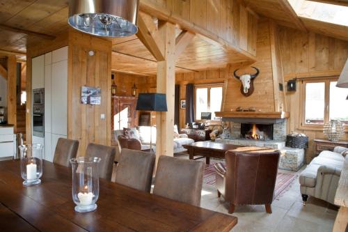 une salle à manger avec une table et une cheminée dans l'établissement Chalet Amelie, à Chamonix-Mont-Blanc