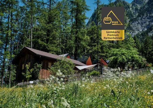 eine kleine Hütte im Wald mit einem Schild in der Unterkunft Älmele - Waldchalets Brandnertal in Brand