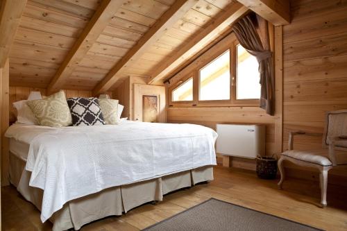 une chambre avec un lit blanc et une fenêtre dans l'établissement Chalet Amelie, à Chamonix-Mont-Blanc