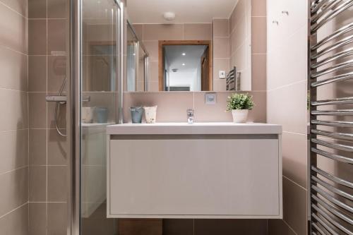 ein Badezimmer mit einem weißen Waschbecken und einer Dusche in der Unterkunft Villa Floria Apartment in Chamonix-Mont-Blanc
