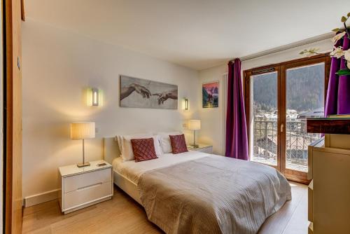 シャモニー・モンブランにあるResidence Les Alpesのベッドルーム1室(紫色のカーテンと窓付きのベッド1台付)