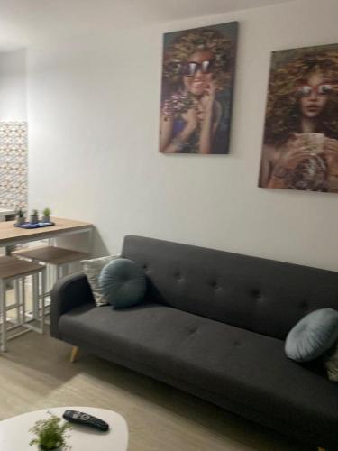 a living room with a black couch and a table at Apartamento acogedor El portil in El Portil
