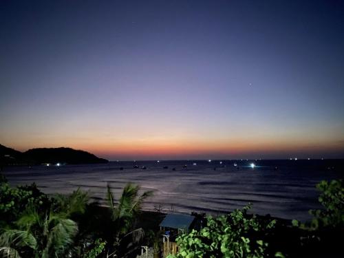 a view of a beach at sunset with boats in the water at Cá Mặn Homestay in Quy Nhon