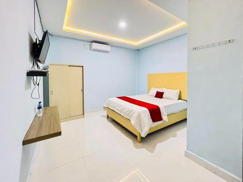ein Schlafzimmer mit einem Bett und einem TV. in der Unterkunft RedDoorz @ Jalan Lintas Pematangsiantar 
