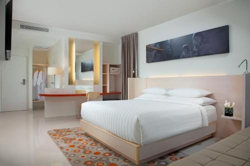 a bedroom with a white bed and a kitchen at Fairfield by Marriott Surabaya in Surabaya