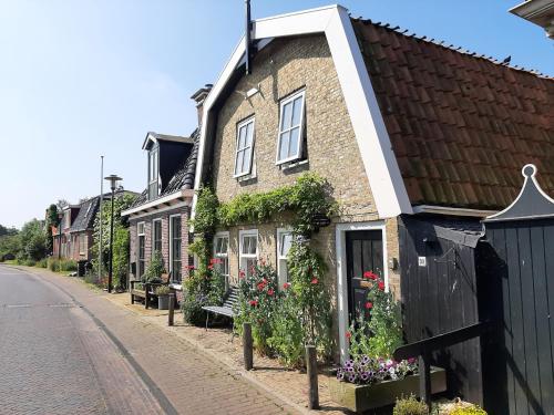 a brick house with flowers on the side of a street at Appartement De Loft in Warns