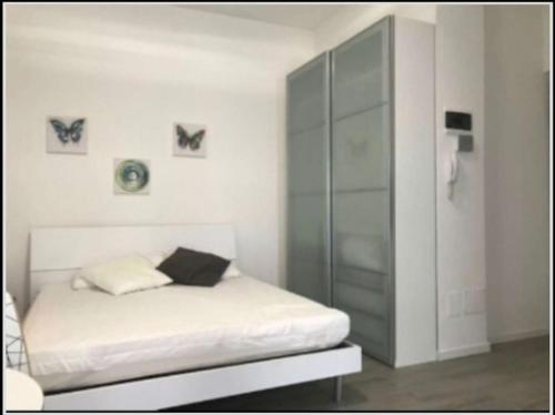ein weißes Schlafzimmer mit einem Bett und einem Glasschrank in der Unterkunft Lolo Apartment in Mailand