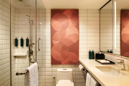 a bathroom with a toilet and a shower and a sink at Hilton Kuching Hotel in Kuching