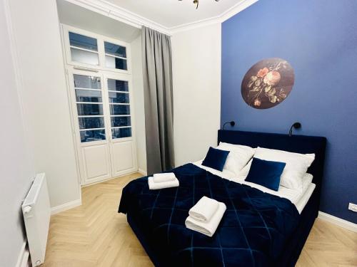 a blue bedroom with a large bed with blue walls at HO!HOUSE Bulwar Staromiejski in Wrocław