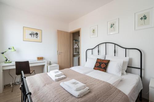una camera da letto con un grande letto con asciugamani di Sunset Towers Apartment a Budapest