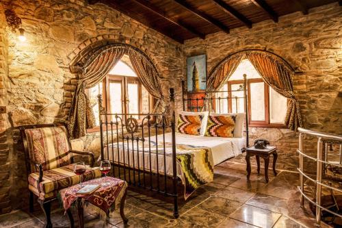 a bedroom with a bed and a stone wall at Stonehouse in Selçuk