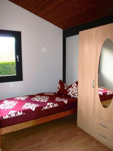 a bedroom with a bed and a window and a door at Ferienpark Fedderwardersiel in Fedderwarderdeich