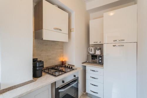 a kitchen with a stove top oven next to a refrigerator at Villetta Panebianco Home in Castagna 11 by Rent All Como in Nesso