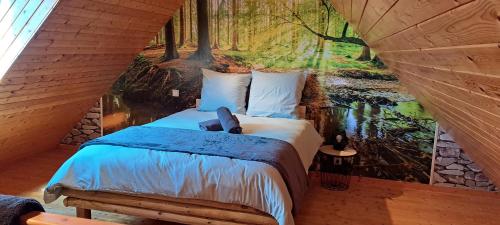 - une chambre avec un lit orné d'une peinture de forêt dans l'établissement Cottage La loge, à Huisnes-sur-Mer