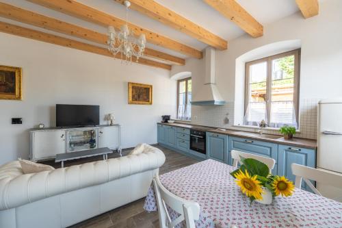 a kitchen with blue cabinets and a table with a white couch at Amalija Apartments in Strunjan