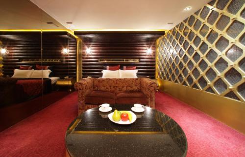 龜山區的住宿－東楓時尚旅館，一间设有一张床和一张桌子及一盘水果的房间