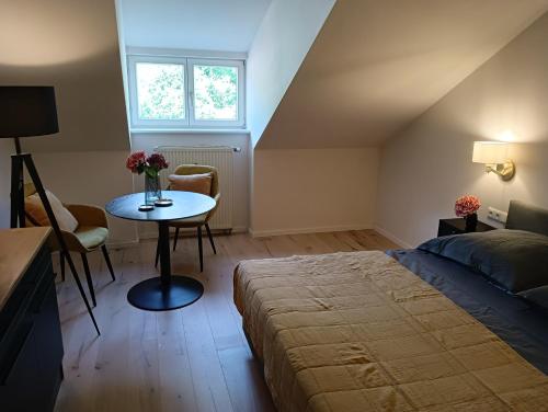 Un dormitorio con una cama y una mesa con flores. en Appartment Schloss-Zeit, en Aschau im Chiemgau