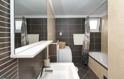 een badkamer met een wastafel, een spiegel en een bad bij Villa Kate in Trogir