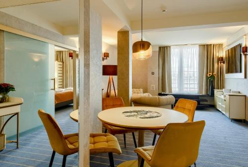 a living room and dining room with a table and chairs at Park Hotel Diament Wroclaw in Wrocław