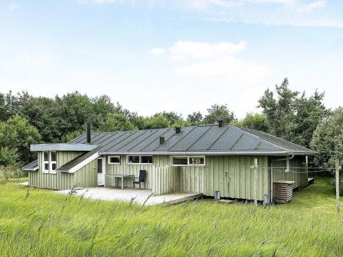 een groen huis met een metalen dak bij 6 person holiday home in Jerup in Jerup