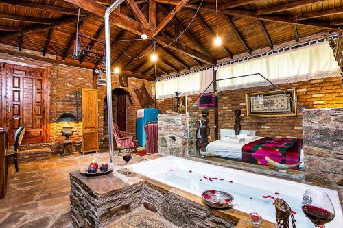 a large room with a bath tub and a bed at Stonehouse in Selçuk