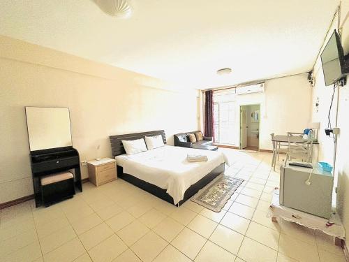 a bedroom with a bed and a television in it at VK &Residence in Kanchanaburi City