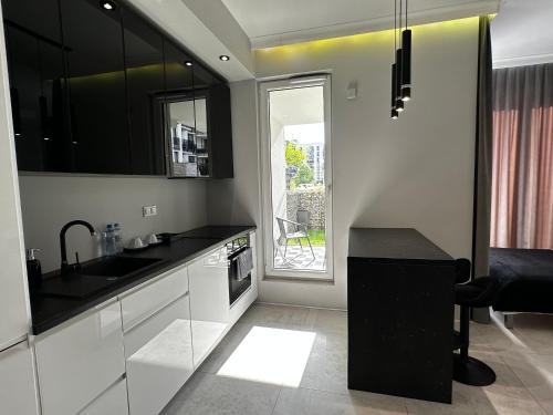 a kitchen with black and white cabinets and a table at Platinium de lux apartament in Warsaw