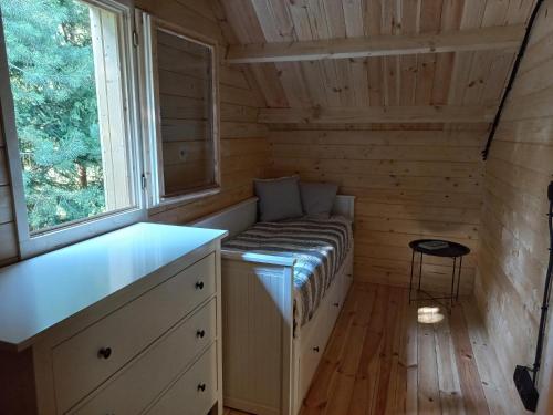 a small room with a bed in a log cabin at Warchały Lake House in Warchały